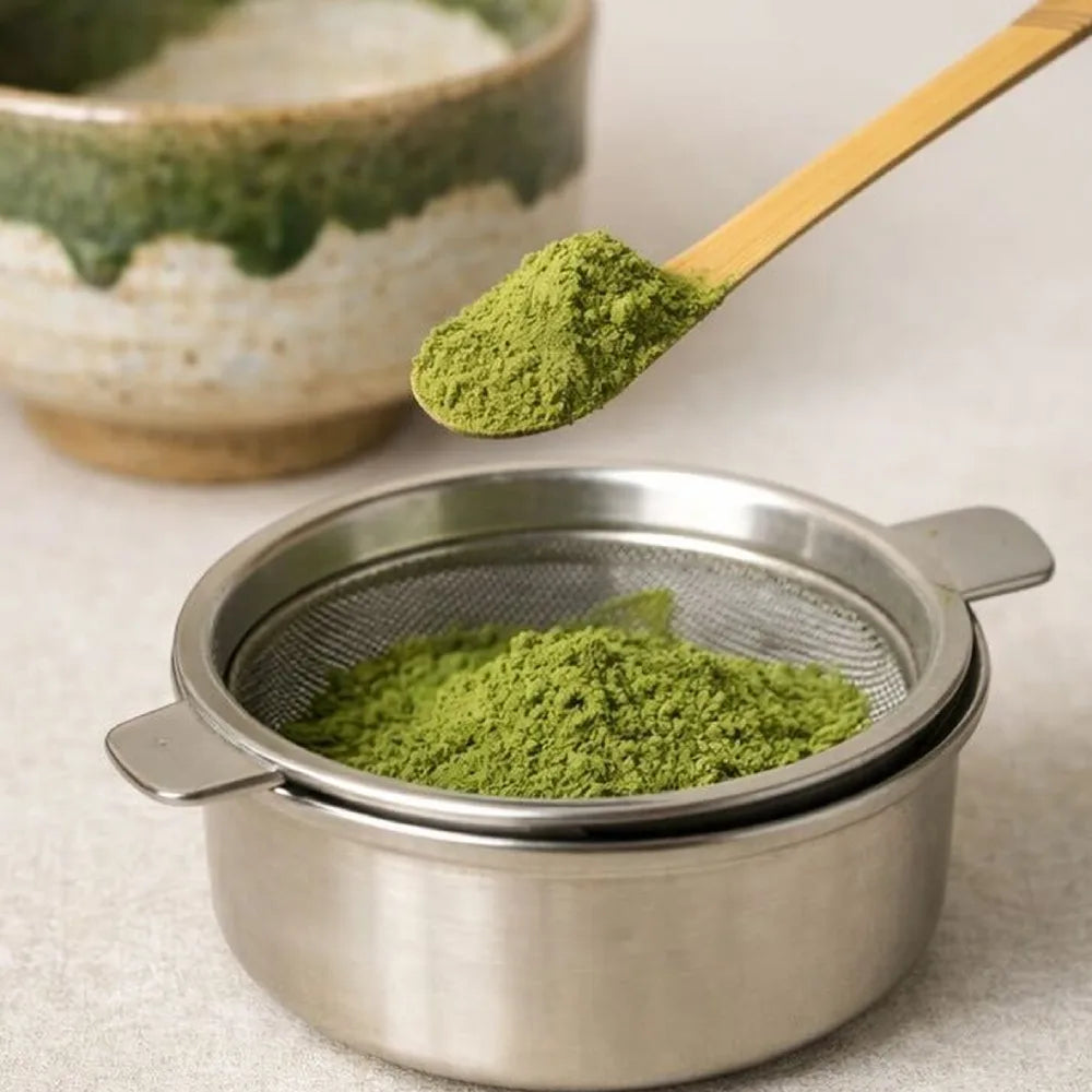 Té matcha en polvo tamizado sobre un cuenco de cerámica: textura fina y color verde intenso — MatchaPro